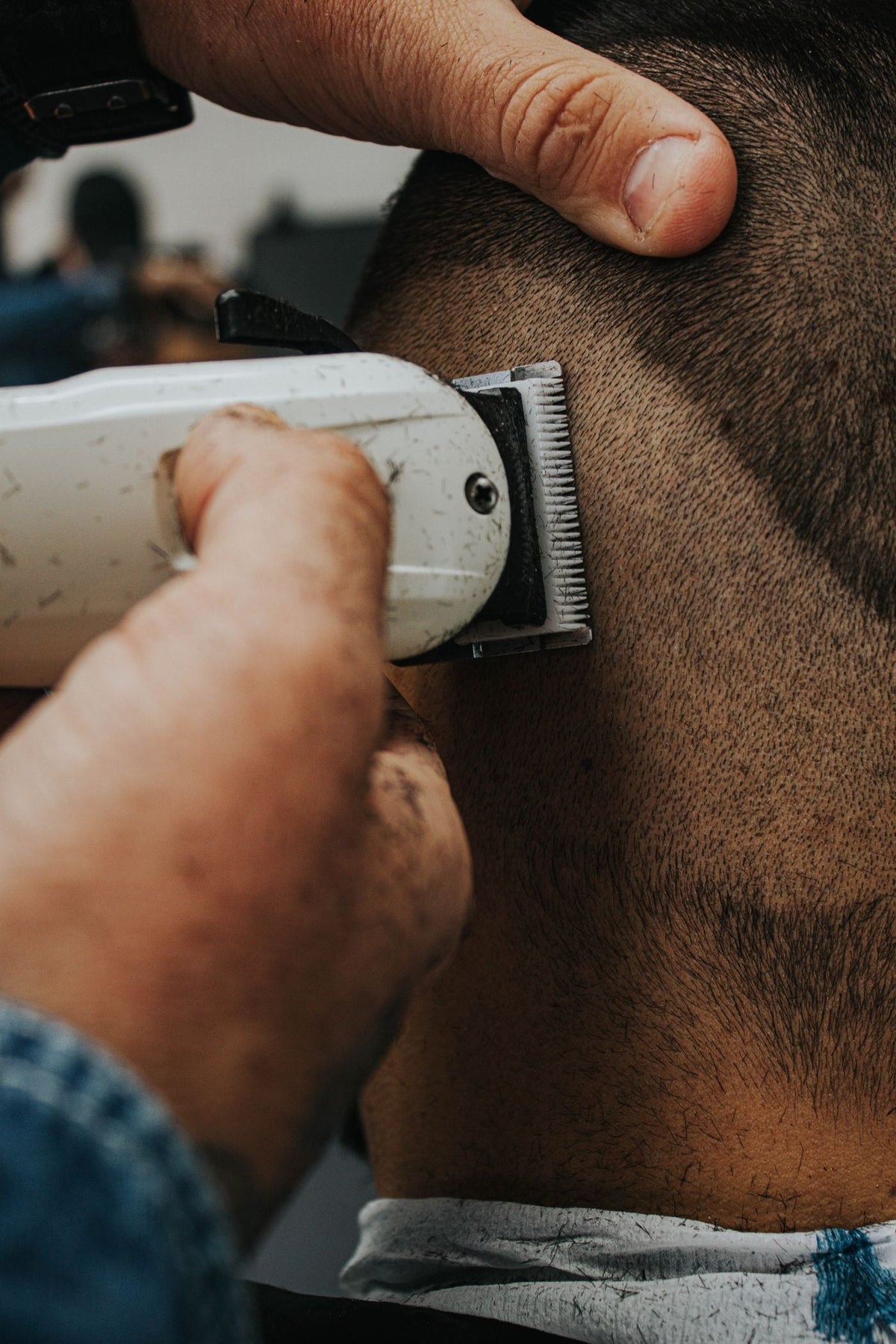 Profesjonell barbering med elektrisk shaver i salong